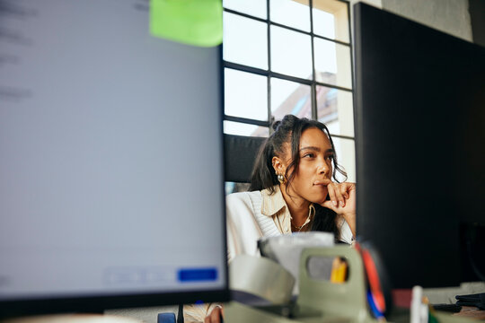 Concentrated businesswoman using computer while sitting in tech office