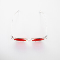 Front view of red tinted glasses with transparent frame, designed for nighttime screen use to reduce blue light and support healthy sleep cycles.