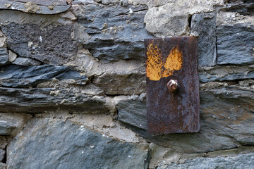 Old stone wall and rusted metal building anchor