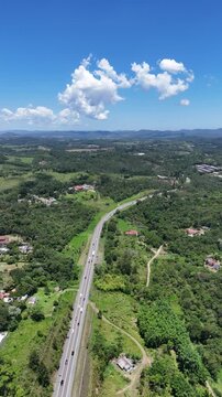 Vis&atilde;o a&eacute;rea vertical v&iacute;deo drone 4k de uma rodovia que atravessa a cidade de Mogi das Cruzes no sentido do litoral paulista no fim de ano