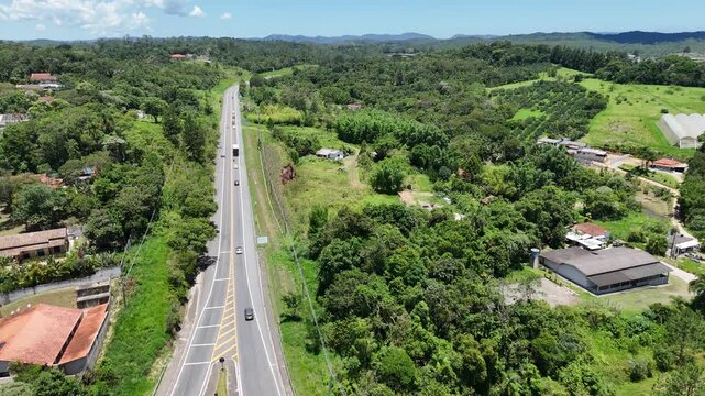 Vista da rodovia em Mogi das Cruzes com destino ao litoral paulista, em meio &agrave; natureza e &aacute;reas verdes, destacando transporte, mobilidade e infraestrutura vi&aacute;ria regional