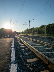 railway track with asphalt platform and sunset light
