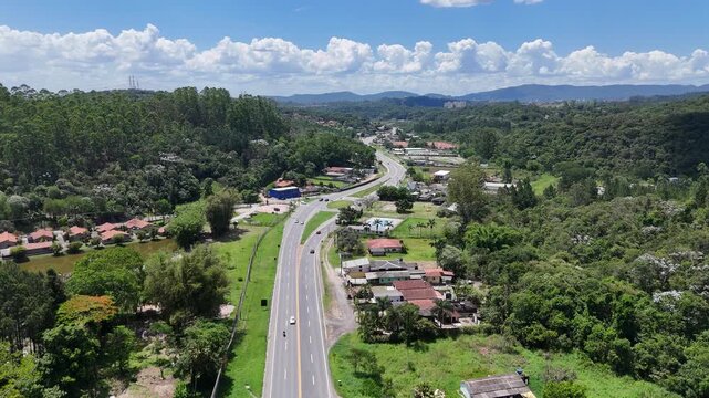 Estrutura vi&aacute;ria em formato de rotat&oacute;ria cercada por vegeta&ccedil;&atilde;o, evidenciando mobilidade sustent&aacute;vel, fluidez do tr&aacute;fego e integra&ccedil;&atilde;o entre cidade e natureza.