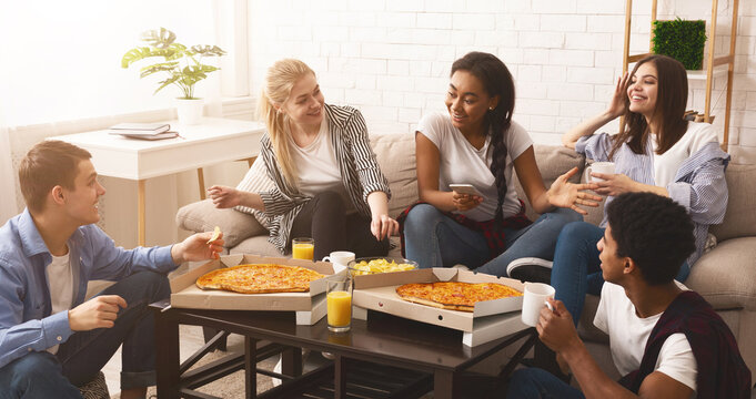 Home party. Friends eating pizza and having fun in living room