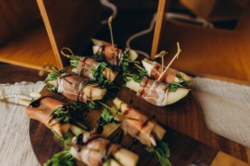 Prosciutto-wrapped fruit skewers serving party appetizers