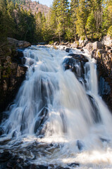 Chute du Diable waterfall in Mont-Tremblant National Park, Quebec, Canada. Long exposure view of powerful flowing water surrounded by forest and rocks.
