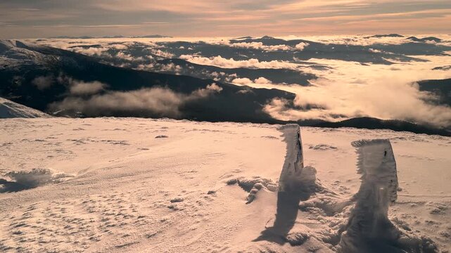 View from Hoverla in winter, Ukraine, Carpathians. Beautiful landscape with blue Carpathian peaks, morning fog in the gorges of Transcarpathia. Snow figures on a peak.
