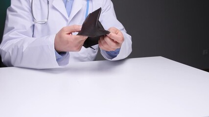 Close up of a doctor in a medical gown at his desk holding an empty wallet, symbolizing financial difficulties, rising healthcare costs, and medical professionals facing economic challenges - Powered by Adobe