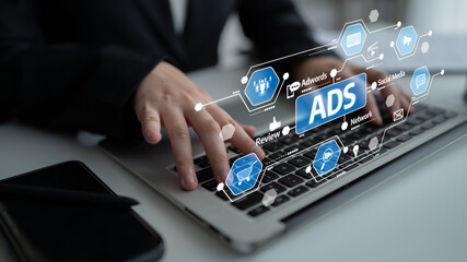 A professional analyzes digital advertisements and social media strategies on a laptop, showcasing modern marketing techniques in a business environment. Tessel