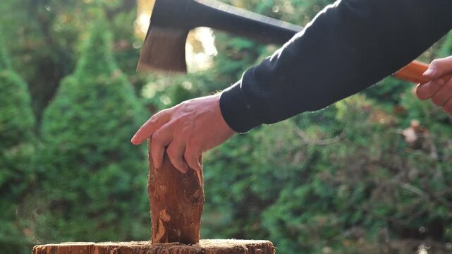 man chops wood with an axe in the street. Wood heating. Solid heating fuel.4k footage