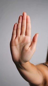 Female hand showing a stop gesture with an open palm and straight fingers
