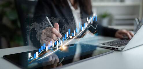 Business professional analyzes financial data and trends using a digital tablet in a modern office....