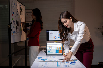 Businesswomen analyzing data overtime, working on financial planning