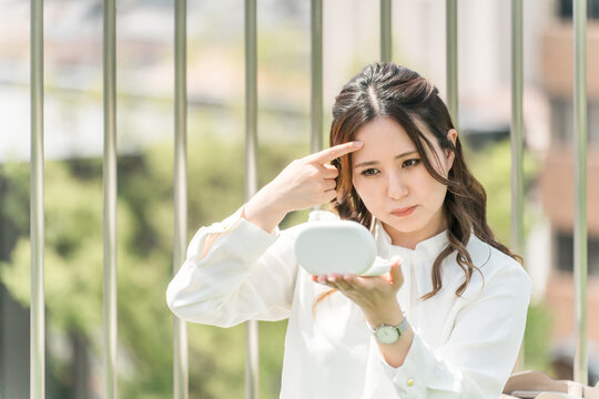 A woman touching up her makeup (forehead, wrinkles, hyaluronic acid)
