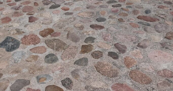 a road made of stones of different sizes in rural areas, a reconstructed ancient road made of multicolored stones, cobblestones and pebbles