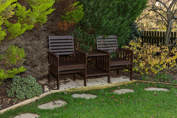 Fototapeta premium Wooden garden seating area with chairs and table in quiet landscaped backyard