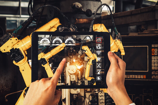 Engineer controls robotic arms by augmented reality industry technology application software. Smart robot machine in future factory working in concept of Industry 4.0 or 4th industrial revolution. - Powered by Adobe