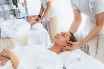 Obraz premium Caucasian couple enjoying relaxing anti-stress head massage and pampering facial beauty skin recreation leisure in dayspa modern light ambient at luxury resort or hotel spa salon. Quiescent