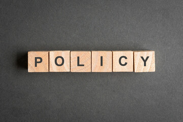 Policy, word on wooden blocks. Top view.