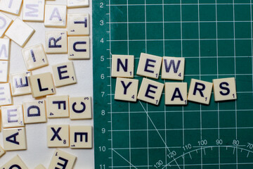 White letter tiles forming the words &ldquo; NEW YEAR&rdquo;
