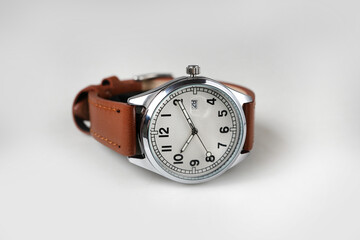 Classic Silver Wristwatch with White Dial and Brown Leather Strap Isolated on White Background