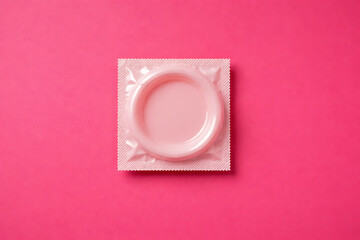 Open condom wrapper on pink background showing the latex product for educational purposes and sexual safety demonstrations in health clinics and medical school training