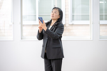 スマホと上を見上げるビジネスウーマン