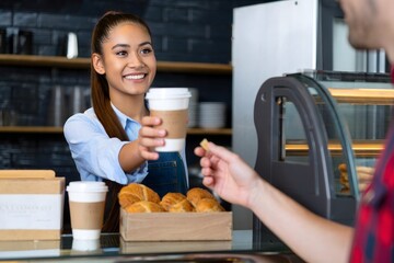 Smiling Cafe Worker Handing Customer Cup of Coffee and Pastry