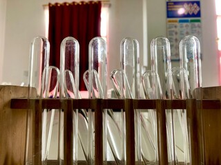 empty glass test tubes sitting in a wooden rack in a laboratory setting