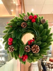 traditional wreath with green fir branches red berries and pine cones