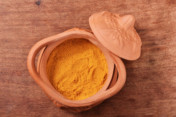 Dry curry powder in bowl on wooden table