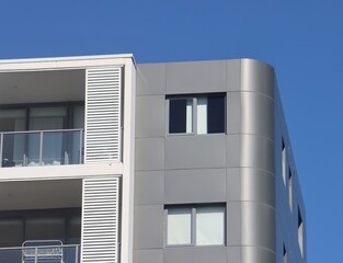 Modern apartment building with curved cladding and balconies © Rose Makin