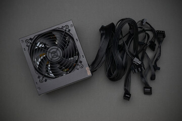 High-Quality Computer Power Supply Unit with Cables on Gray Background