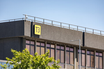 Exterior view of Terminal 3 (T3) signage on a building at Melbourne Airport, Australia. Transport infrastructure, passenger terminals, and aviation architecture. 