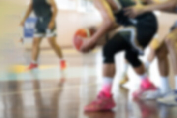 Blurred background of action shot of basketball player dribbling on court. Shoes and ball handling...