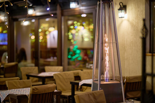 Cozy outdoor cafe with patio heaters and festive string lights
