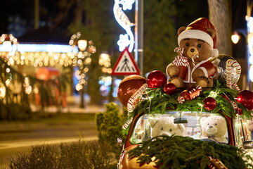Festive christmas display with santa bear and holiday decorations on car roof
