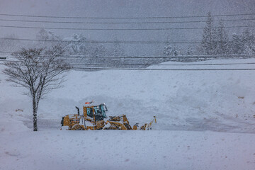 積雪した道路で行われる早朝の除雪作業