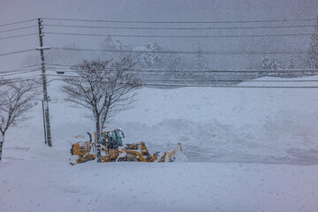 積雪した道路で行われる早朝の除雪作業