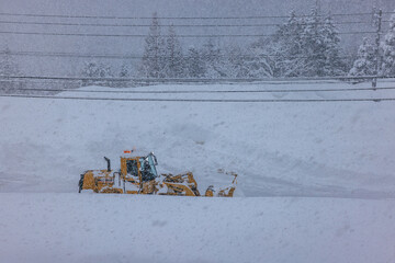 積雪した道路で行われる早朝の除雪作業