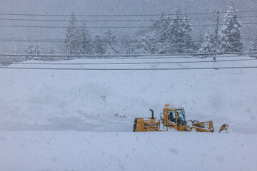 積雪した道路で行われる早朝の除雪作業