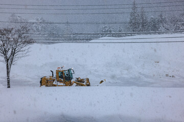 積雪した道路で行われる早朝の除雪作業