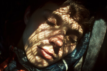 Close-up portrait of a young man with closed eyes and patterned light across his face, expressing emotional vulnerability, introspection, and quiet psychological tension.