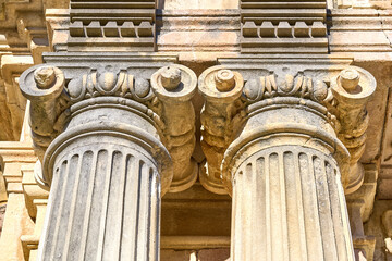 Ancient roman columns with corinthian capitals in sunlight
