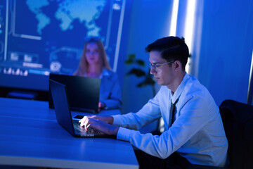 Focused work in a modern office setting with digital map displays and blue lighting