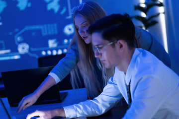 Team collaboration in a modern office setting during a digital project presentation at night