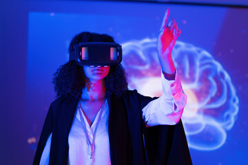 Woman uses virtual reality headset to explore brain activity in a colorful scientific demonstration at a technology event
