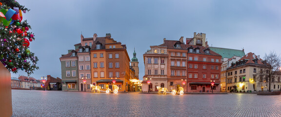 Illuminated Christmas decorations and tree at main square in Warsaw, Poland during winter evening