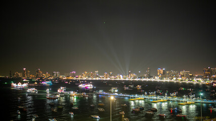 Dazzling night view of city skyline illuminated with colorful lights with boats glowing on the...