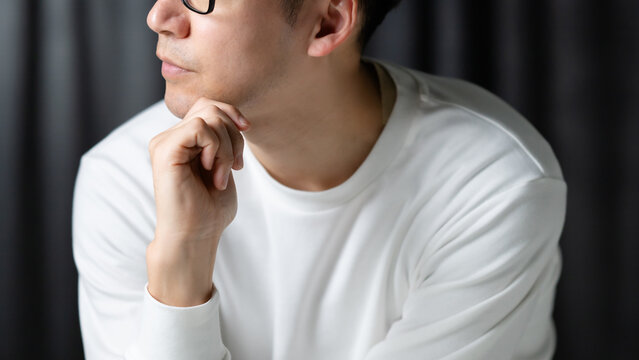 顎に手を当てて考える男性